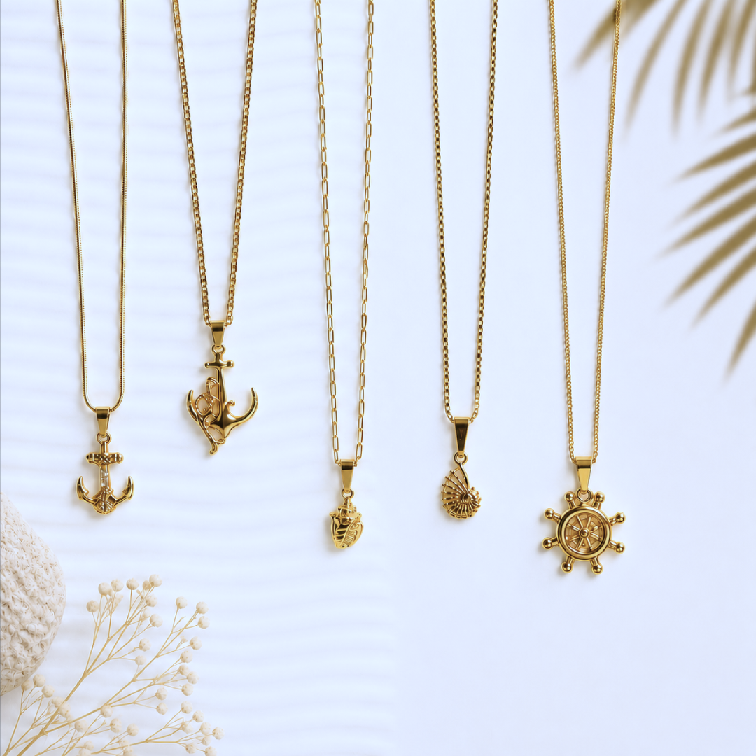 Gold nautical pendant necklaces on white background