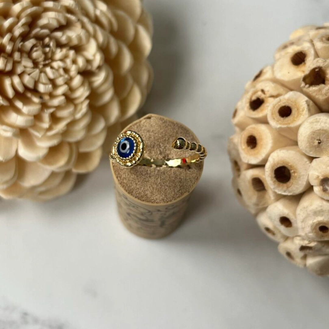 Gold evil eye ring on cork display