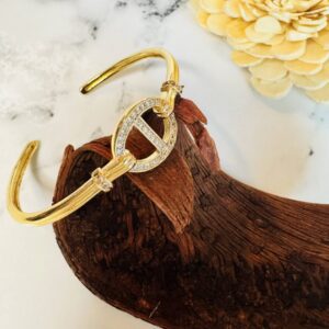Gold cuff bracelet with rhinestone circular centerpiece