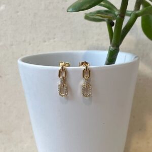 Gold link drop earrings on white pot