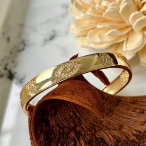 Gold bangle with diamond-studded eye motifs