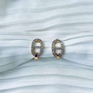 Gold oval crystal earrings on white fabric